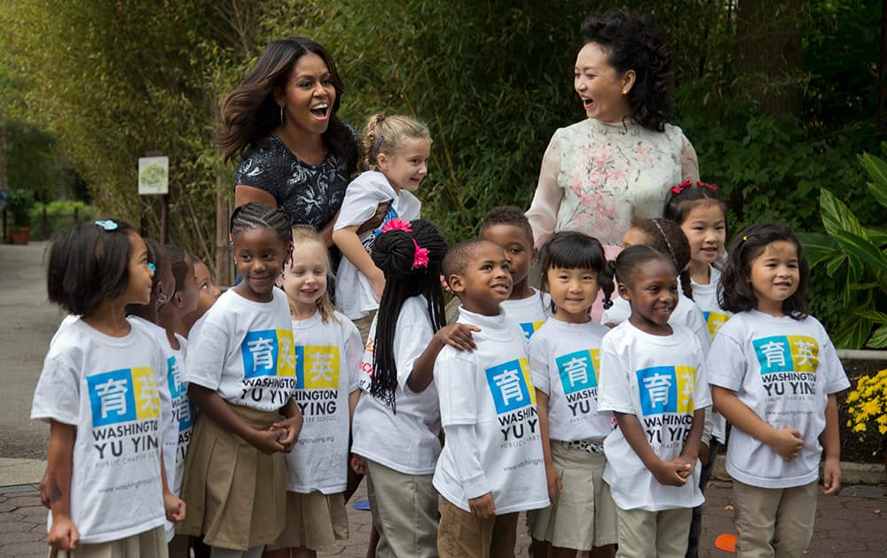 First lady Michelle Obama and China’s first lady Peng Liyuan, are greeted by third graders from Yu Ying Public Charter School in Washington, during a visit to the Smithsonian’s National Zoo in Washington.