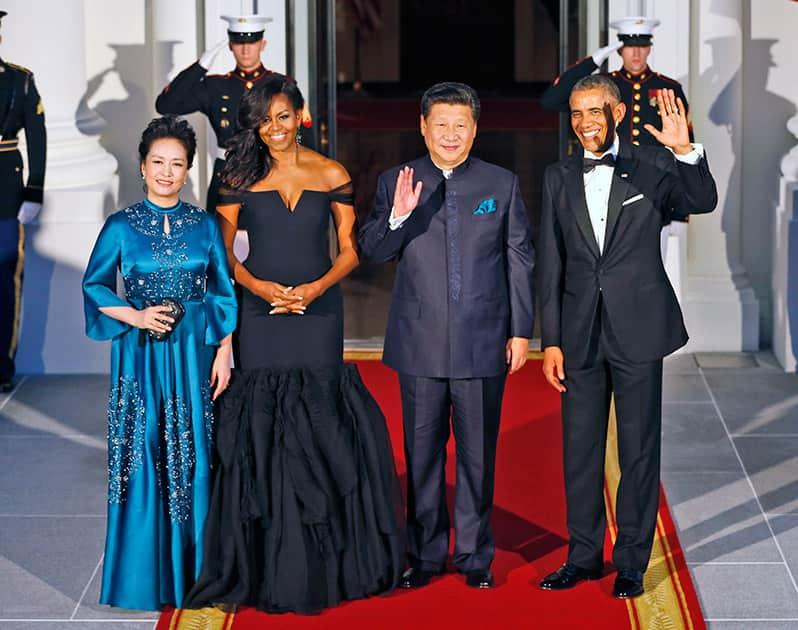 President Barack Obama and Chinese President Xi Jinping, wave on the North Portico with wives Peng Liyuan, and first lady Michelle Obama as they arrive for a State Dinner at the White House in Washington.