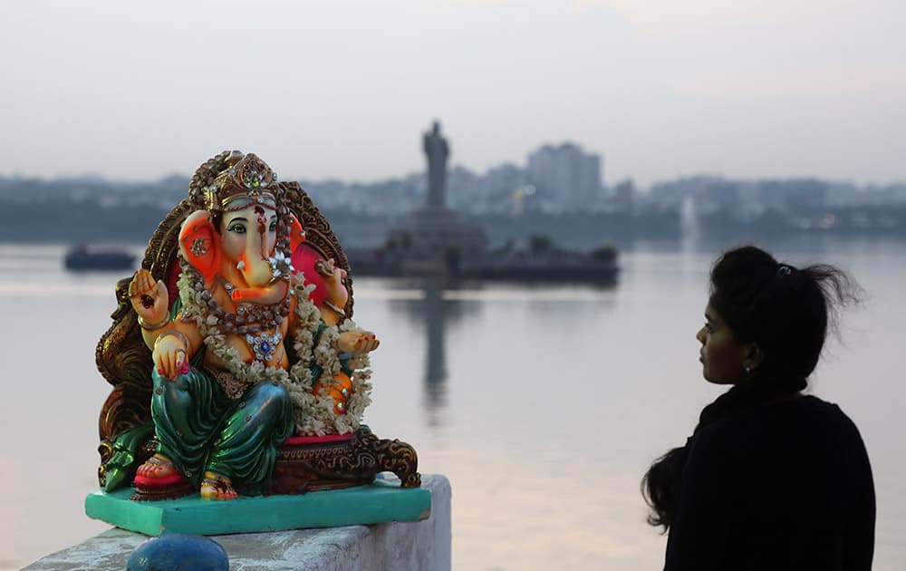 A woman stands near an idol of Hindu elephant-headed God Ganesha before immersing it in Tankbund during Ganesh Chaturthi festival celebrations in Hyderabad.