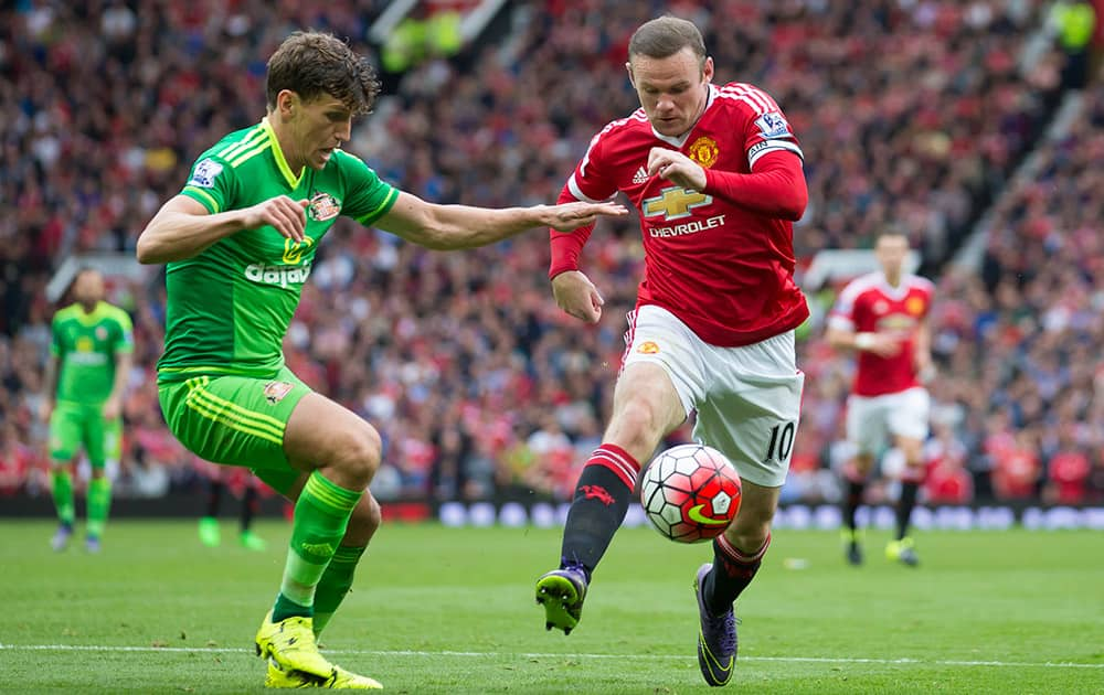 Manchester United's Wayne Rooney, right, fights for the ball against Sunderland's Billy Jones during the English Premier League soccer match between Manchester United and Sunderland at Old Trafford Stadium, Manchester, England.