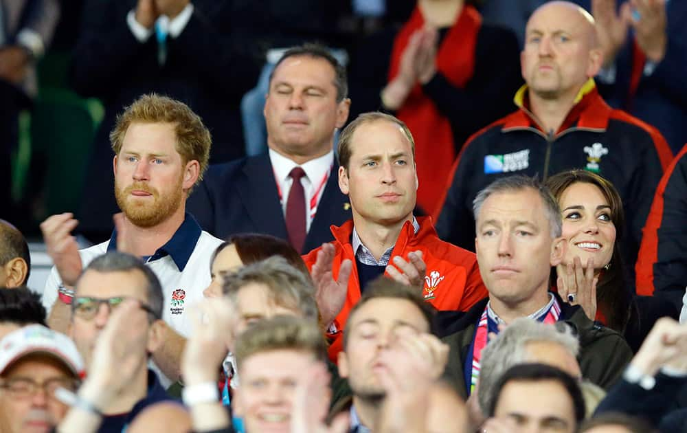 Britain’s Prince William, Kate, the Duchess of Cambridge and Prince Harry, left, applaud after the national anthems ahead of the Rugby World Cup Pool A match between England and Wales at Twickenham Stadium, London.