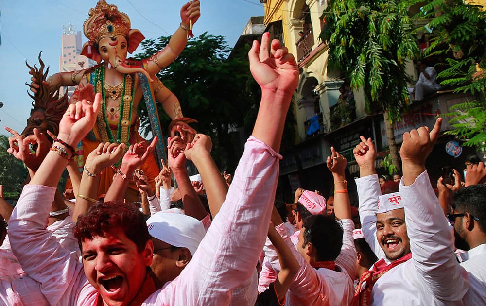 Devotees cheer as an idol of elephant-headed Hindu god Ganesha is taken through the streets prior to its immersion in the Arabian Sea in Mumbai.