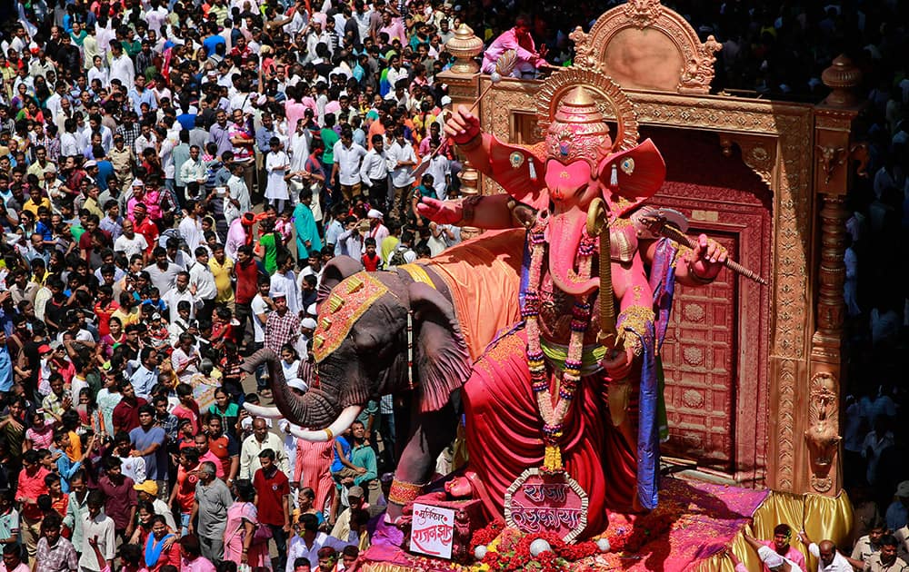 Devotees gather around as an idol of elephant-headed Hindu god Ganesha is taken through the streets prior to its immersion in the Arabian Sea in Mumbai.