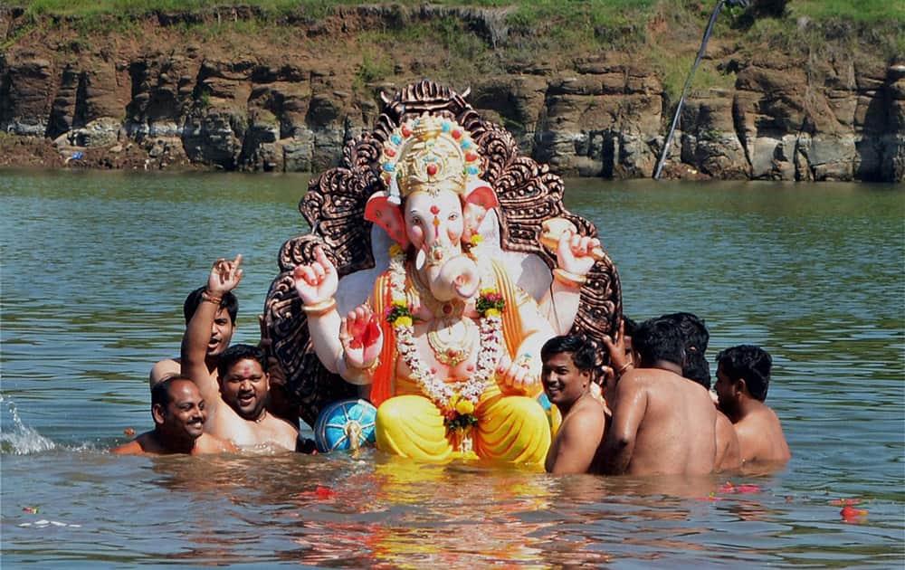 Devotees immersing a Lord Ganesha idol in Krishna river on the last day of Ganesh festival in Karad, Maharashtra.