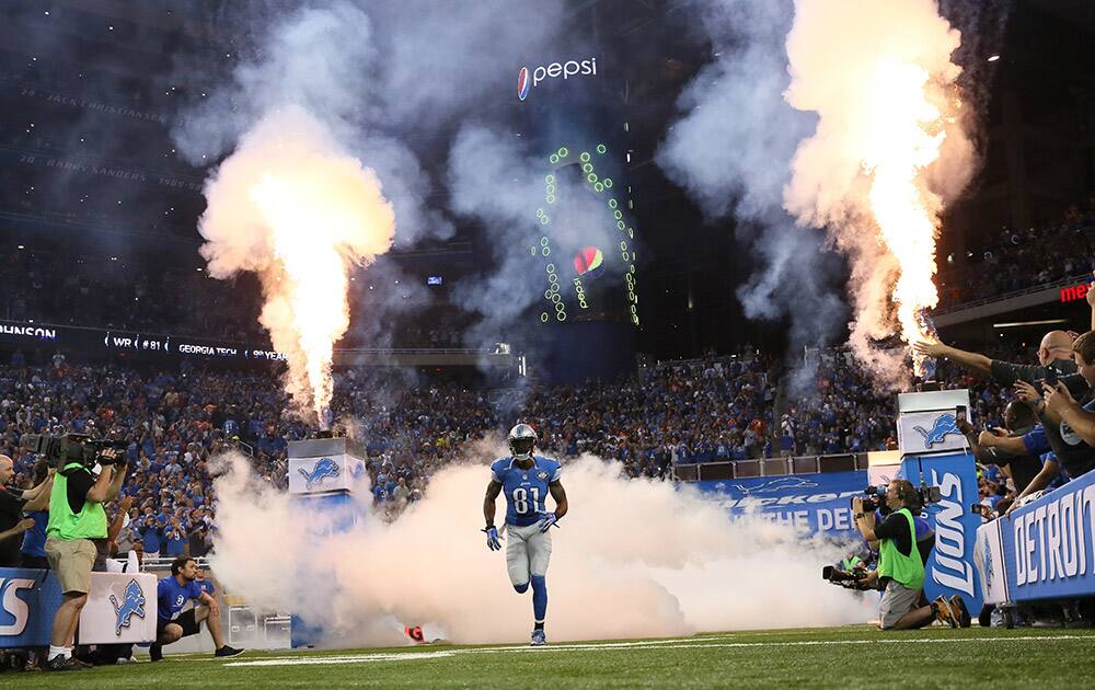 Detroit Lions wide receiver Calvin Johnson runs out during player introductions for the Lions' NFL football game against the Denver Broncos.