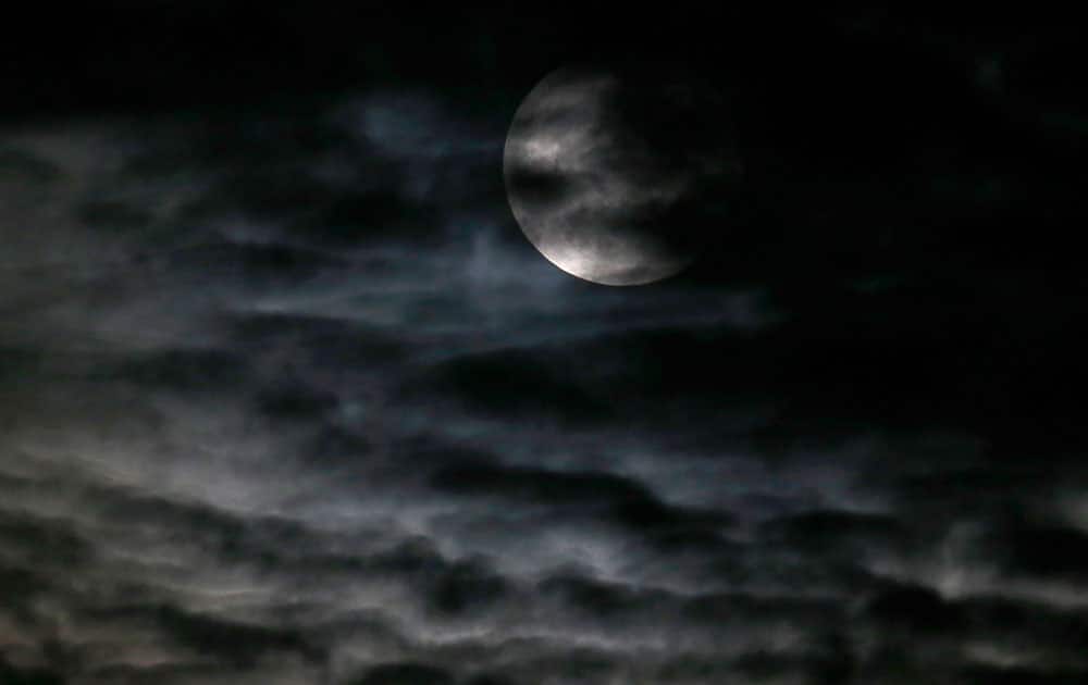 Clouds obscure the so-called supermoon before a lunar eclipse in Chicago.