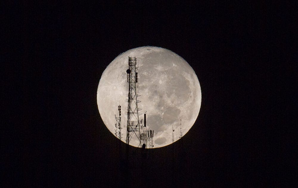 A full moon silhouettes television and radio antennas on Boutilier Mountain, in Port-au-Prince, Haiti.