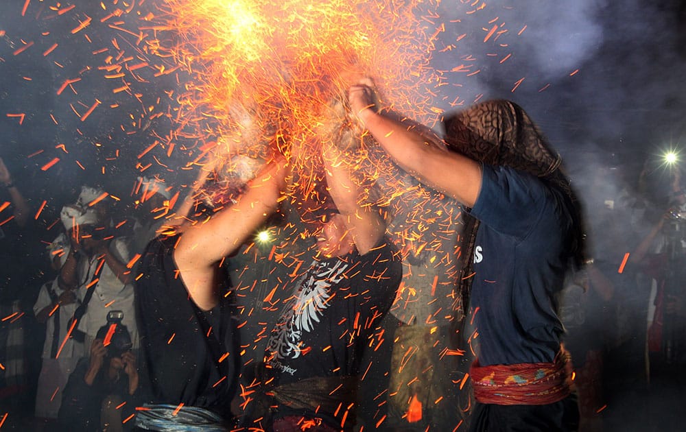 men lash each other with burning coconut husks during the annual 