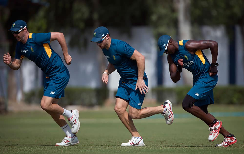 South African cricket players, from left to right, Kyle Abbott, David Miller and Kagiso Rabada, run during a practice session in New Delhi.