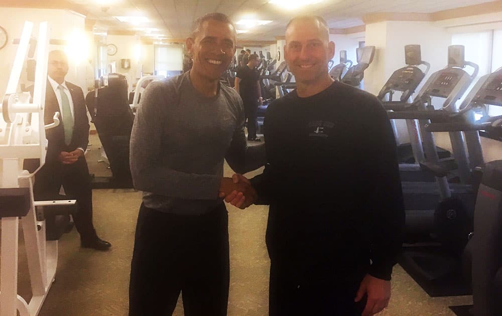 President Barack Obama, left, shakes hands with Boston Red Sox Interim Manager Torey Lovullo in the exercise room of the New York Palace Hotel, in New York. 