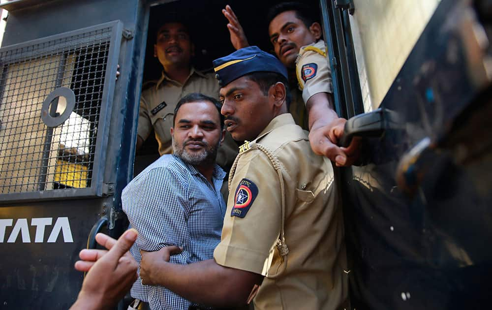 One of the men accused in the 2006 Mumbai train bombings is escorted by policemen from a prison to a court in Mumbai. Court has sentenced five suspected Islamic militants to death and given seven others life in prison for bombing attacks nine years ago on seven Mumbai commuter trains that killed 188 people and wounded more than 800. 