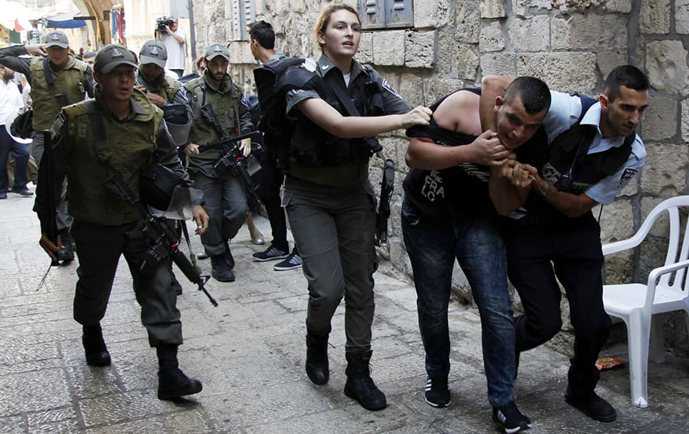 Israeli policemen arrest a Palestinian man during confrontations in the Old City in Jerusalem.