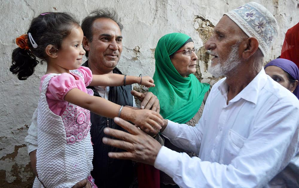A Haj pilgrim is greeted by relatives on his arrival from Mecca, in Srinagar.