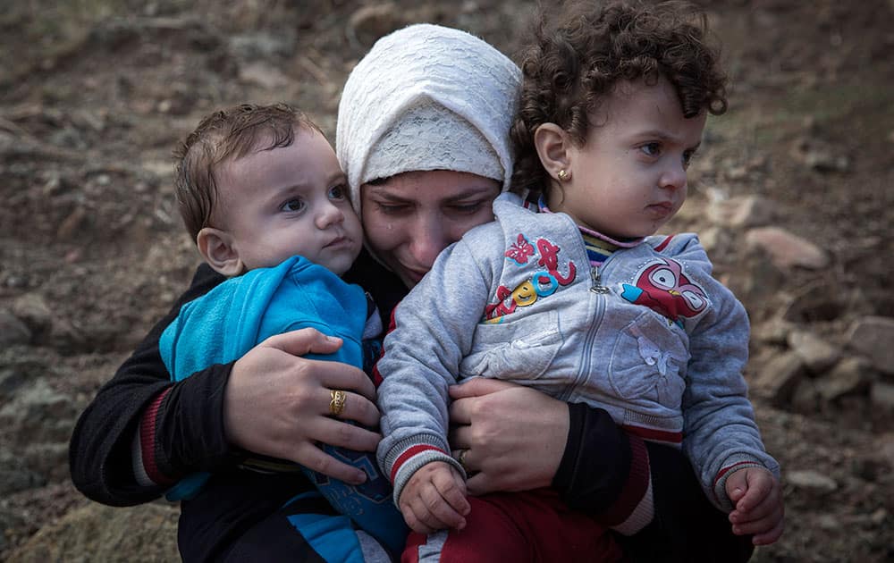 A Syrian mother cries as she hugs her children after spending five hours on a dinghy to approach the Greek island of Lesbos from the Turkish coasts.
