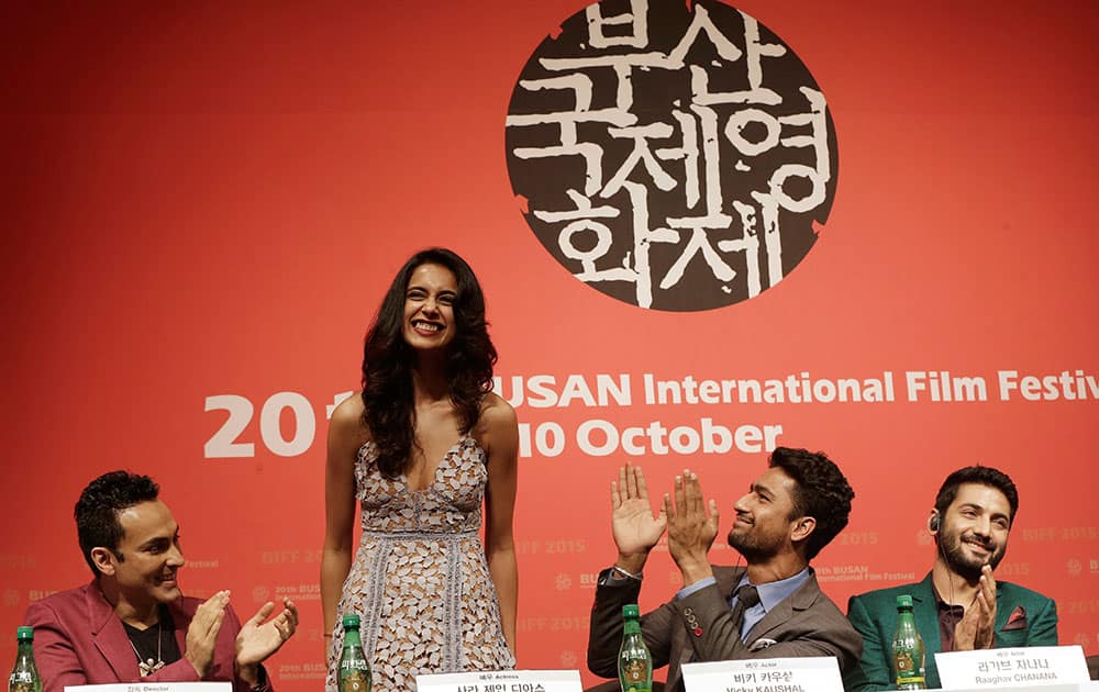 Indian actress Sarah Jane Dias, second from left, is congratulated by Indian director Mozez Singh, left, actor Vicky Kaushal and actor Raaghav Chanana , right, after she sings a song during a press conference for the Busan International Film Festival opening movie 