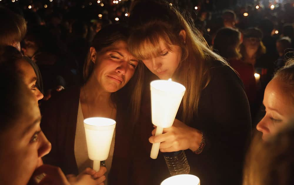 Kristen Sterner, left, and Carrissa Welding, both students of Umpqua Community College, embrace each other during a candle light vigil for those killed during a fatal shooting at the college.