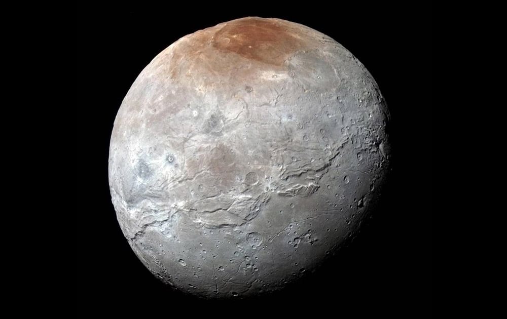 This image released by NASA on Thursday, shows Charon, in enhanced color captured by NASA's New Horizons spacecraft just before closest approach. Massive canyons and fractures are clearly visible on Charon, which is more than half of Pluto’s size.