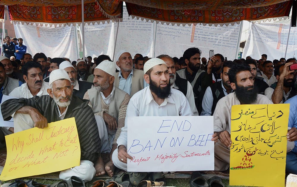 A group of people shout slogans holding placards during a protest against Beef ban by J&K High Court, in Srinagar.