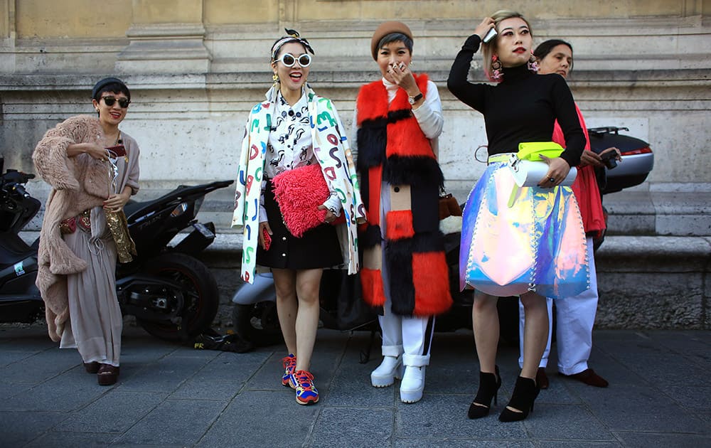 Fashion lovers pose for a picture outside Chalayan' Spring-Summer 2016 ready-to-wear fashion collection presented during the Paris Fashion Week, in Paris.