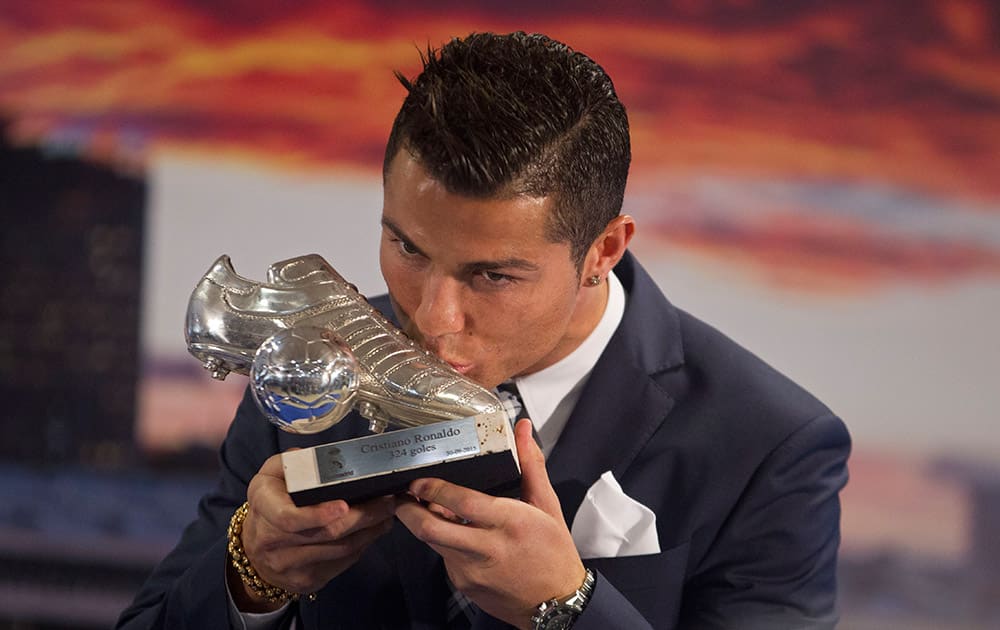 Real Madrid’s striker Cristiano Ronaldo kisses a silver boot award for scoring the most goals for the club during a ceremony at the Santiago Bernabeu stadium in Madrid, Spain.