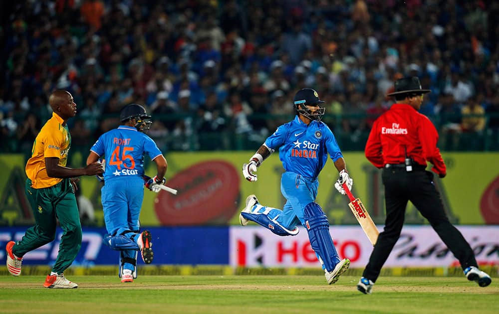 Virat Kohli, second right, and Rohit Sharma run between the wickets during the first Twenty20 cricket match against South Africa in Dharmsala.