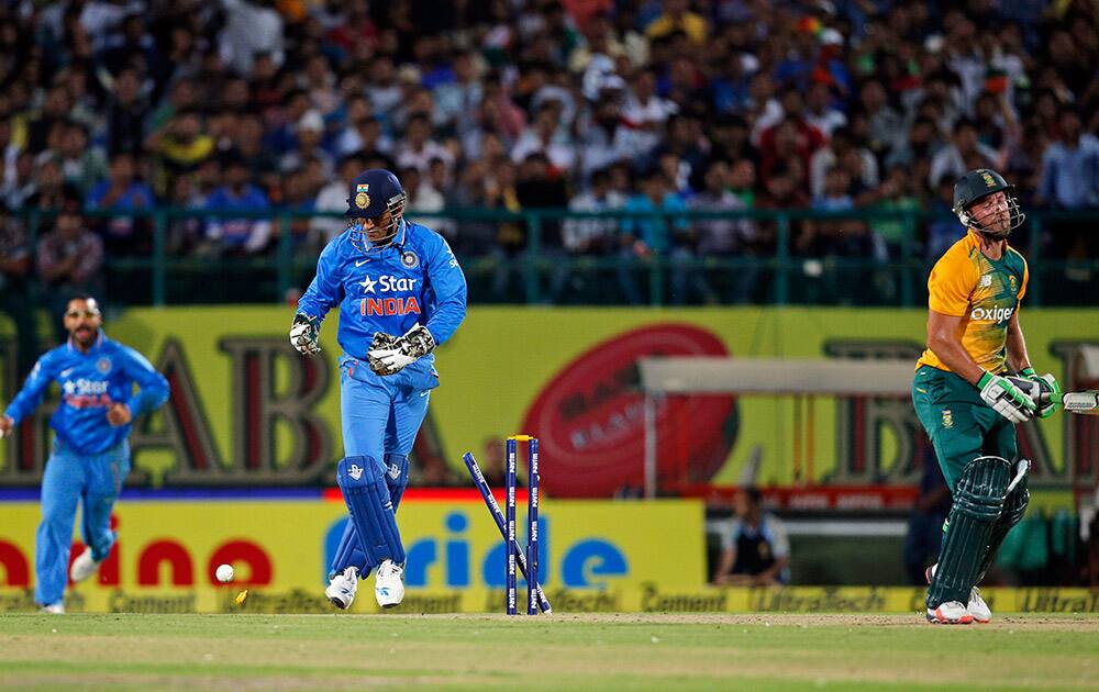 Mahendra Singh Dhoni, center, celebrates the dismissal of South Africa's AB de Villiers during their first Twenty20 match in Dharmsala.