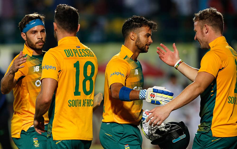 South Africa's Jean-Paul Duminy, second right, celebrates with teammate David Miller as he leaves the ground after winning the first Twenty20 match against India in Dharmsala.