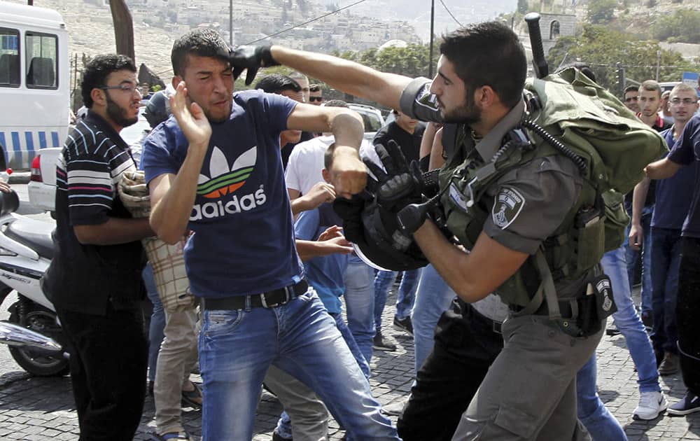 A Israeli border policeman exchanges blows with a Palestinian man during a confrontation after Friday prayers outside the Old City in Jerusalem.