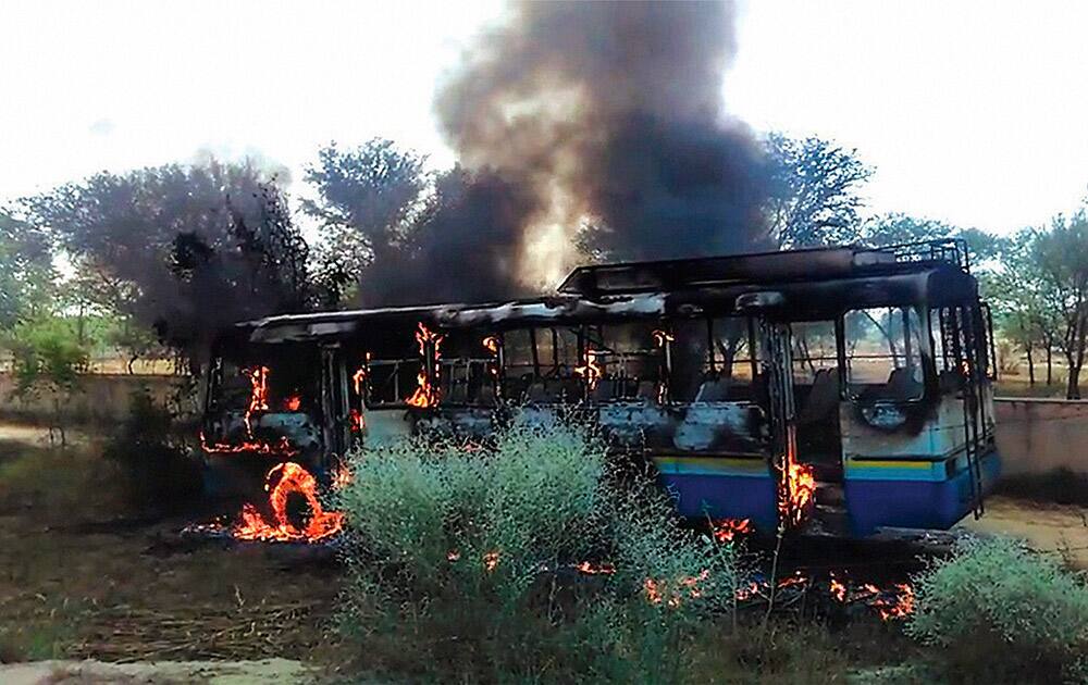 A bus that was set affire by the irate villagers in protest over killing of a youth in Hisar.