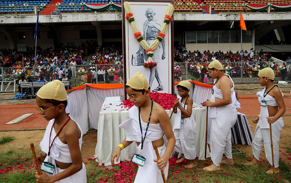 School children dressed as India’s independence leader Mahatma Gandhi arrive to participate in an attempt to create a Guinness record, during celebrations to mark Gandhi’s birth anniversary in Bangalore.