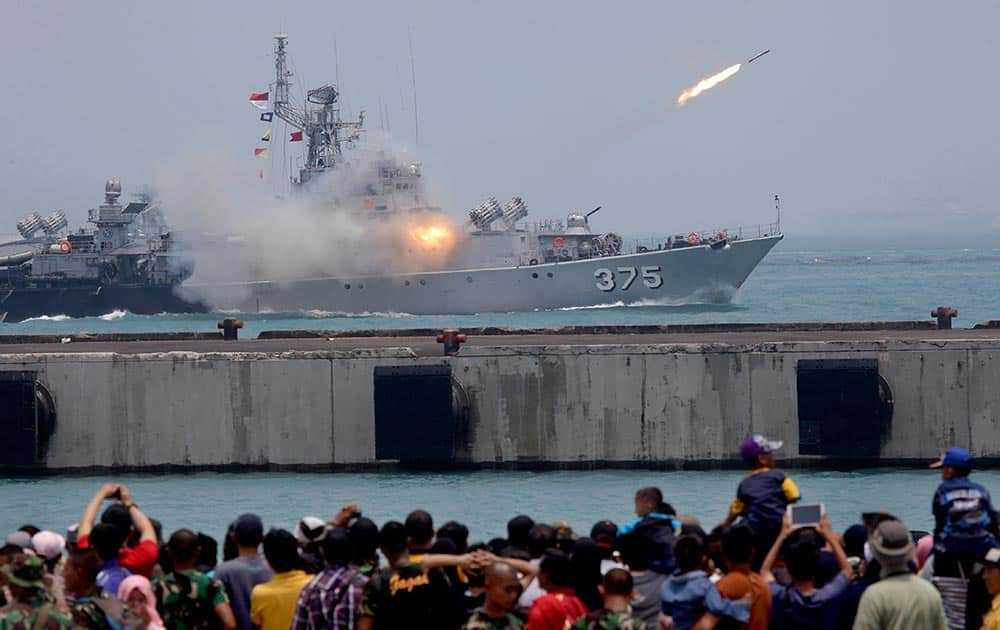 People watch as missiles are launched from an Indonesia military ship for a rehearsal for the upcoming parade held to commemorate the 70th anniversary of the Indonesia Armed Forces in Cilegon, Banten province, Indonesia.