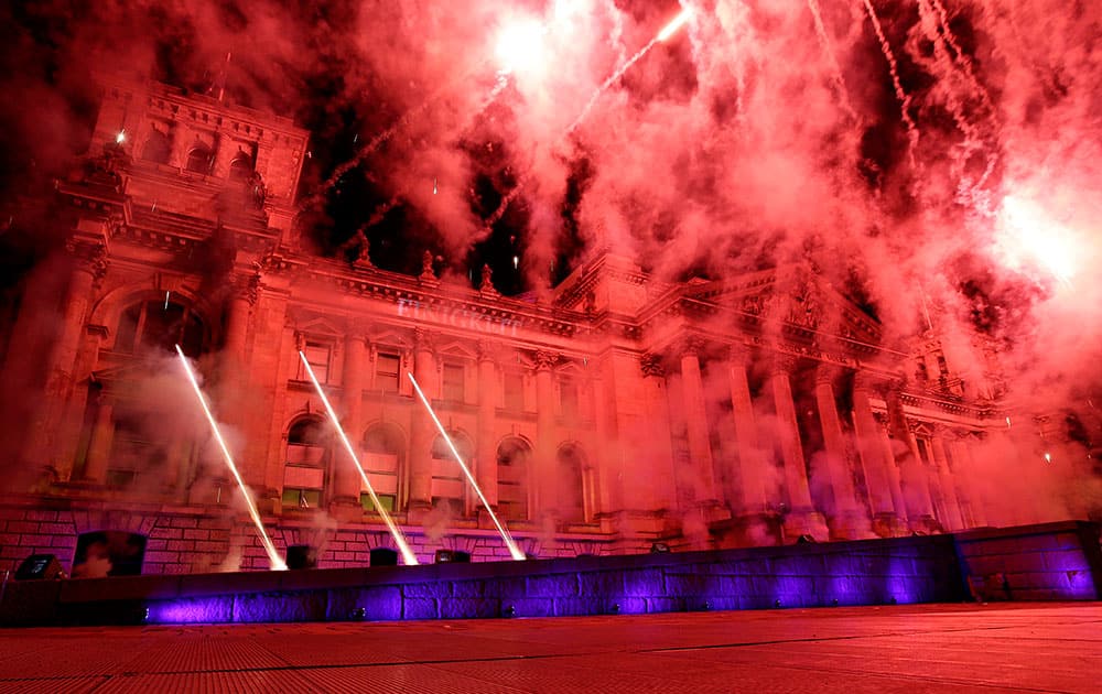 The Reichstag building, home of the German Federal Parliament, Bundestag, is illuminated by fireworks during a party to celebrate the 25th anniversary of Germany's reunification in Berlin, Germany.