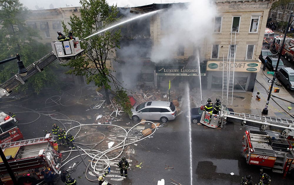 Firefighters work at the at the scene of an explosion at a three-story building in the Borough Park neighborhood in the Brooklyn borough of New York. Firefighters in New York say one person is dead and three more have been injured in an apparent explosion and fire.