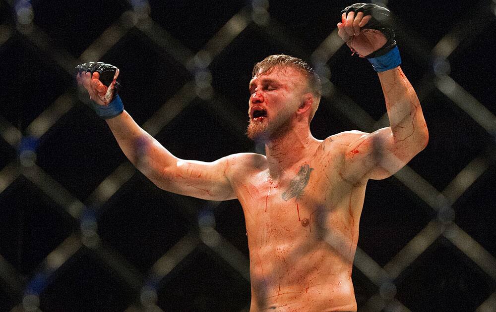 UFC Light Heavyweight challenger Alexander Gustasson raises his arm after his mixed material arts bout at MMA UFC 192 in Houston.