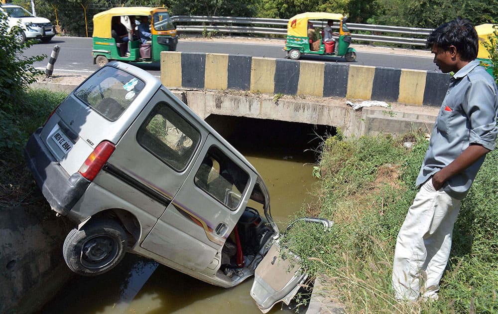 A car overturns and falls down in a drain at Expressway in Gurgaon.