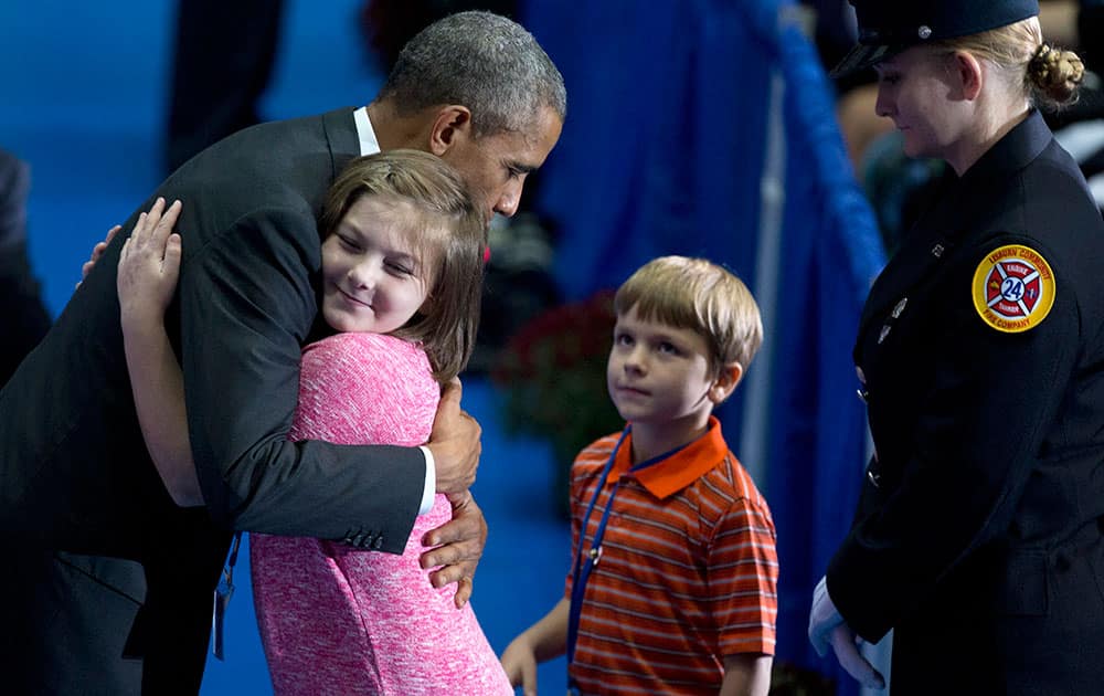 President Barack Obama hugs a young girl as he greets family members and coworkers of fallen firefighters during the National Fallen Firefighters Memorial Service at Mount St. Mary’s University’s Knott Athletic Recreation Convocation Complex (ARCC) in Emmitsburg, Md.