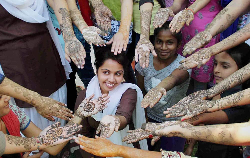 Girls Show their hands designed with henna during a mehndi design competition at a collage, in Allahabad.