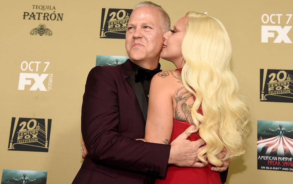 Lady Gaga, right, kisses executive producer/director/writer Ryan Murphy as they arrive at the Los Angeles premiere screening of 