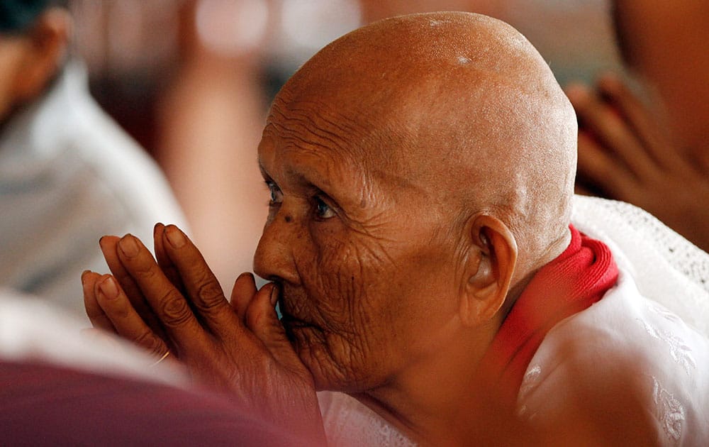 A follower listens to a Buddhist monk chanting at a Buddhist pagoda during celebrations of Pchum Ben, or Ancestors' Day, on the outskirts of Phnom Penh, Cambodia.