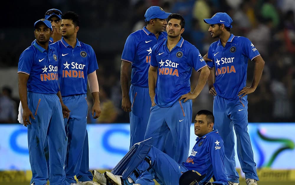 Indias captain M S Dhoni with teammates as play is interrupted by spectators throwing bottles onto the pitch during the second T20 cricket match against South Africa in Cuttack.
