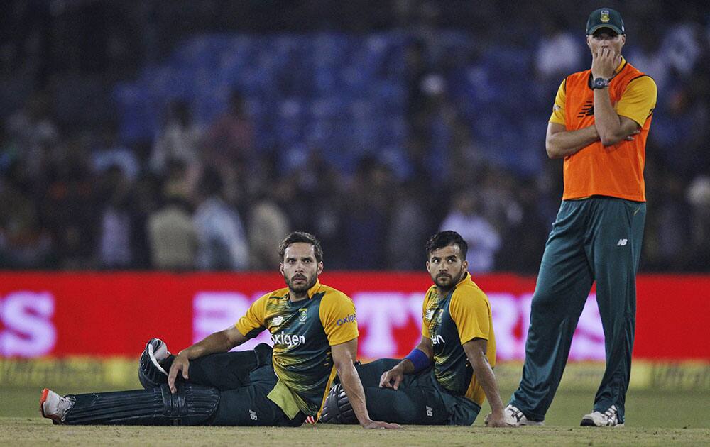 South African batsmen Farhaan Behardien and Jean-Paul Duminy sit and watch as their second Twenty20 cricket match against India is disrupted after spectators threw bottles in Cuttack.