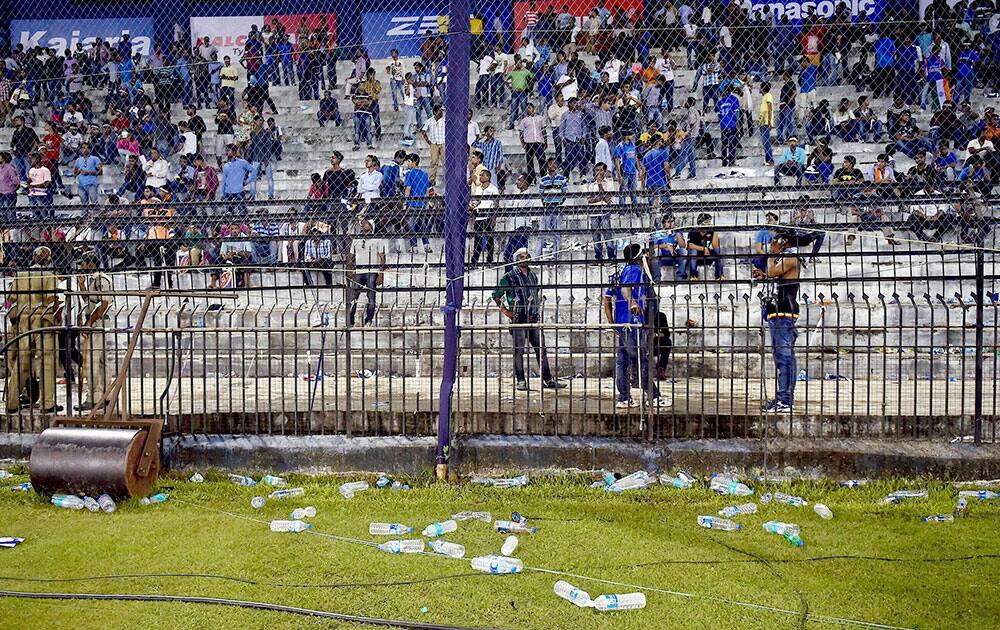 Water bottles thrown by spectators lie on the ground as the second Twenty20 cricket match between India and South Africa is disrupted in Cuttack.