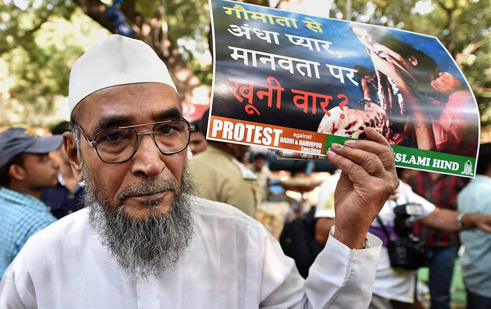 An elderly man displays a placard during a protest against Dadri lynching incident, at Jantar Mantar in New Delhi.