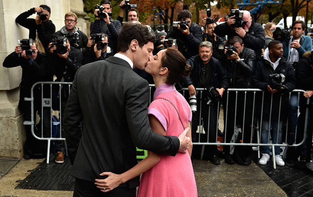 British actress Kaya Scodelario kisses her boyfriend Benjamin Walker as they arrive at Chanel's Spring-Summer 2016 ready-to-wear fashion collection presented during the Paris Fashion Week.