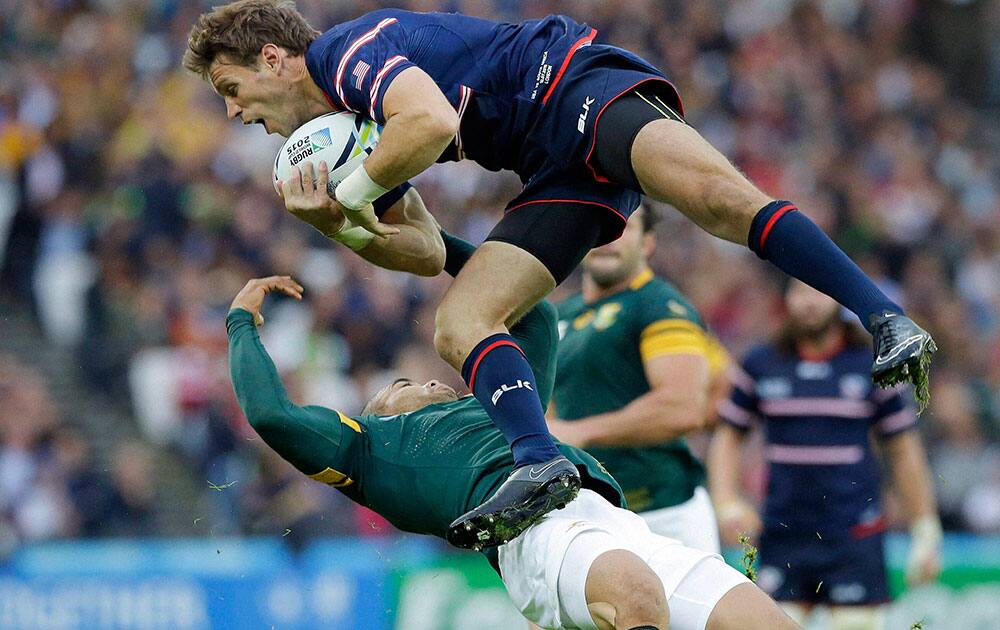 South Africas Bryan Habana and Blaine Scully of the USA, top, compete for the ball during the Rugby World Cup Pool B match between South Africa and USA at the Olympic Stadium, London.