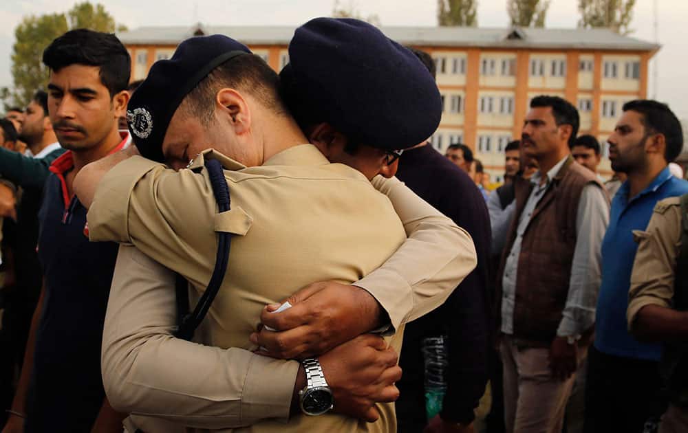 police officers embrace each other as they cry during the wreath laying ceremony of their colleague officer Altaf Ahmed in Srinagar.