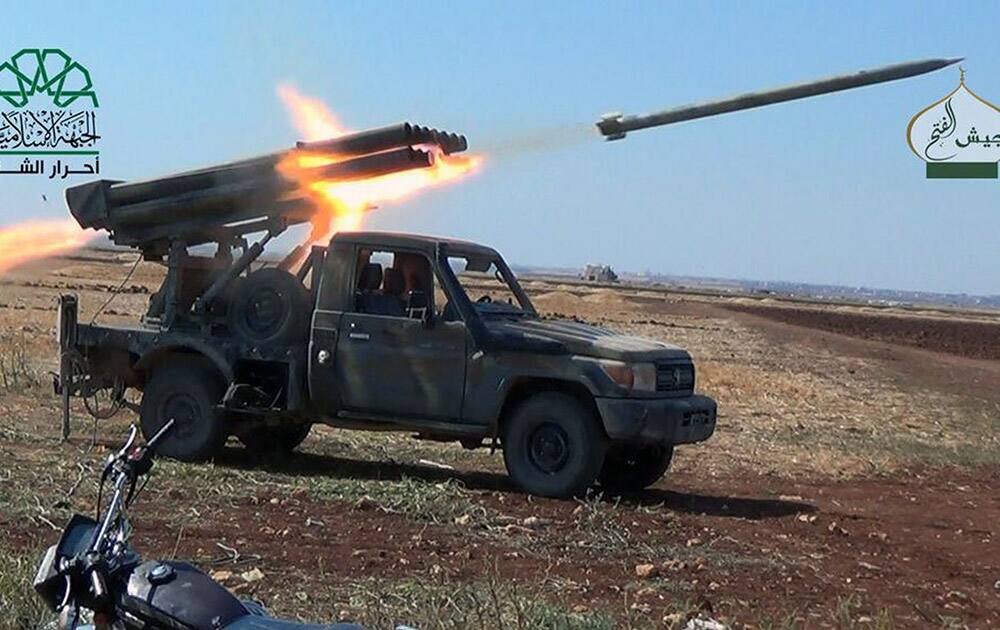 fighters from Ahrar al-Sham fire rockets toward the northwestern Shiite villages of Foua and Kfarya in Idlib, Syria.