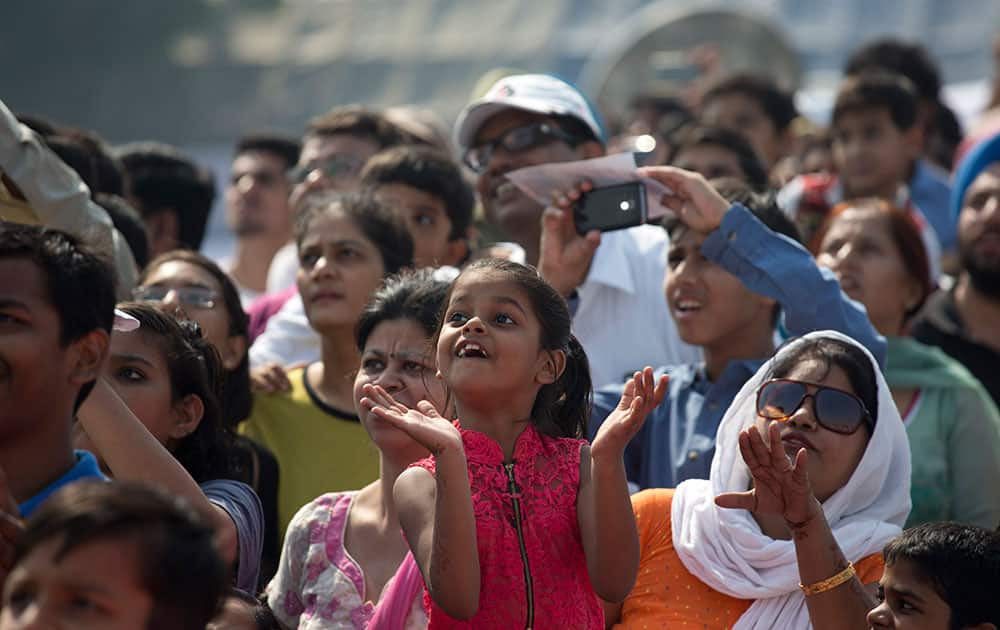 A girl applauds as she watches aerobatic performances during Air Force Day parade at Hindon Air Force base near New Delhi.