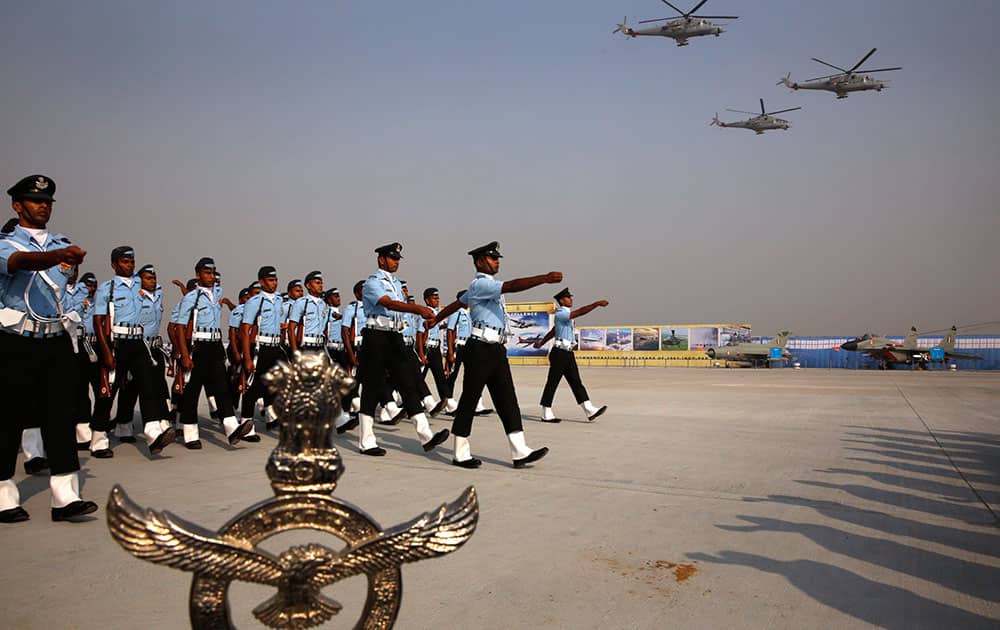Indian Air Force Mi-35 helicopters fly above soldiers marching during the Air Force Day parade at Hindon Air Force base near New Delhi.