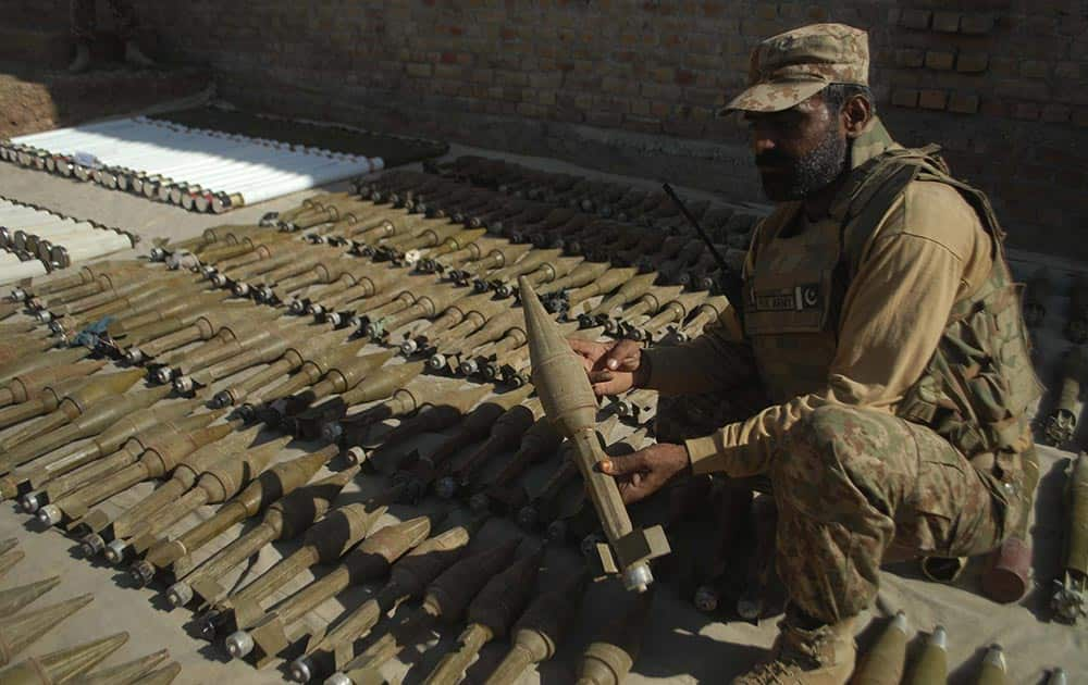 A Pakistani solider holds a grenade the security forces recovered during a crackdown operation in Pakistani tribal area of Bara.